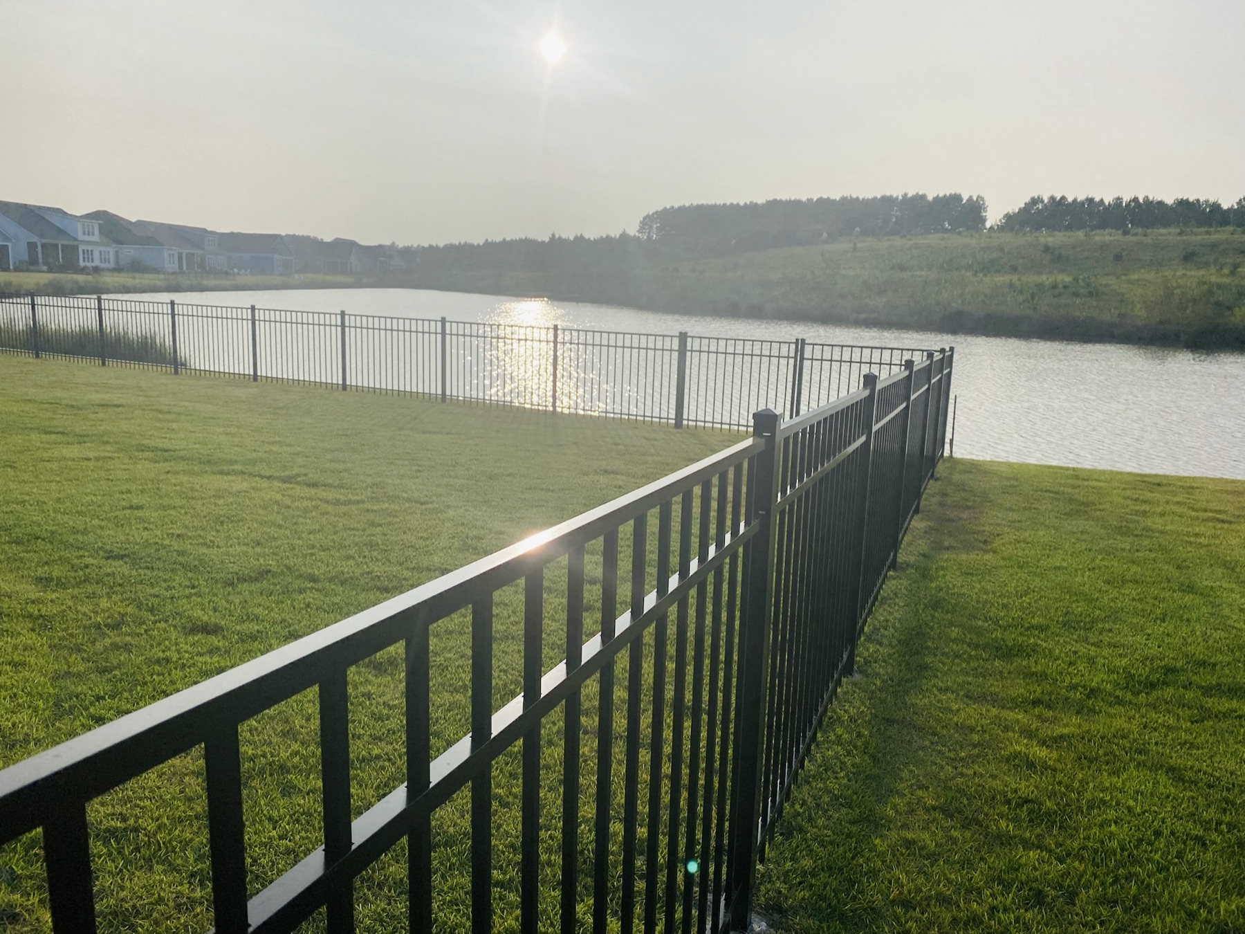 Black aluminum perimeter by the pond at sunrise, Lowcountry