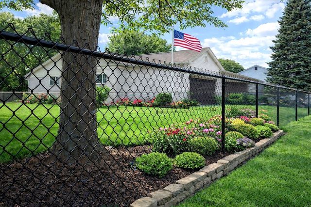 Black chain link around landscaped residential yard, style we install