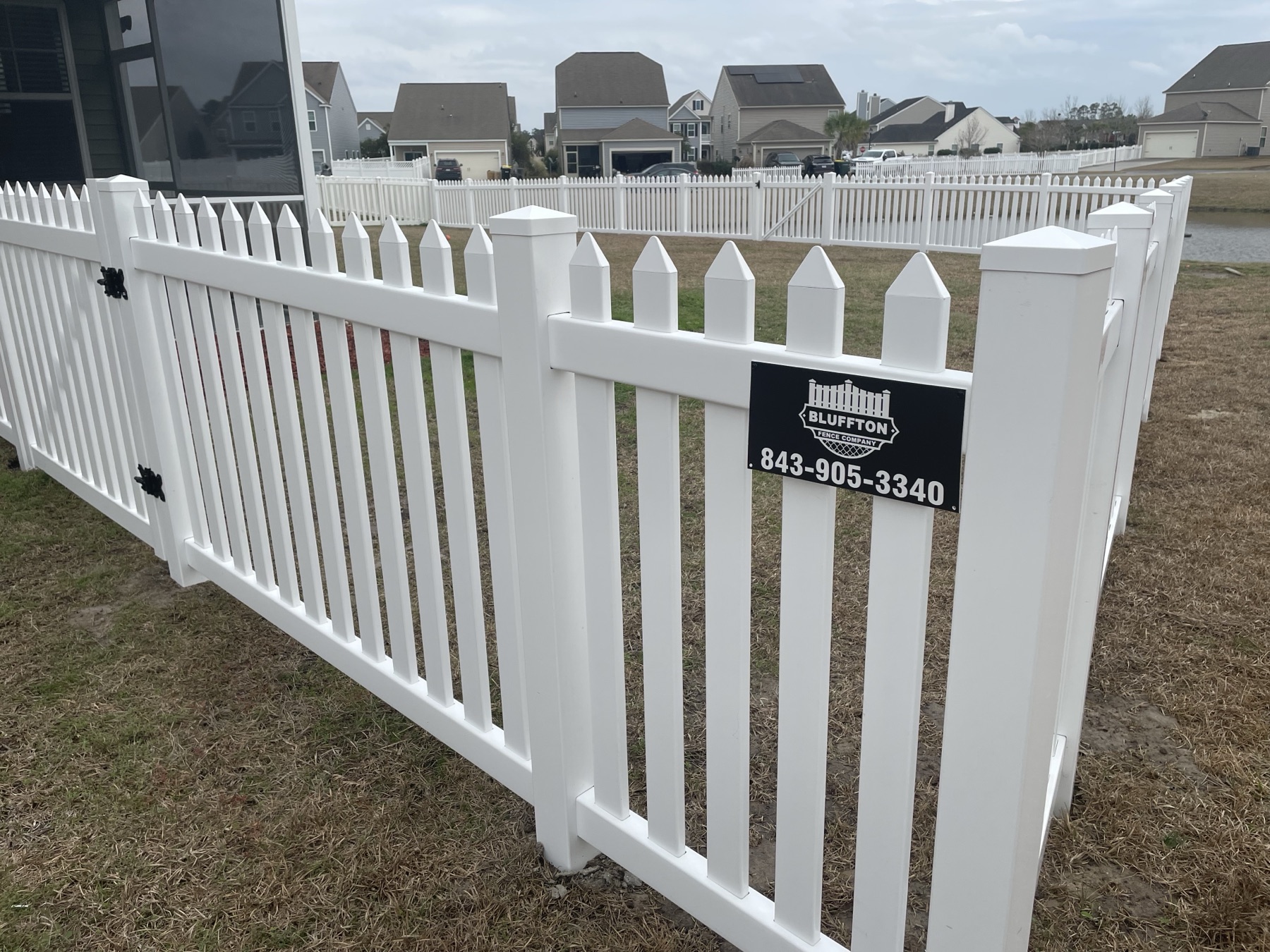 White vinyl scallop picket with branded sign, Bluffton