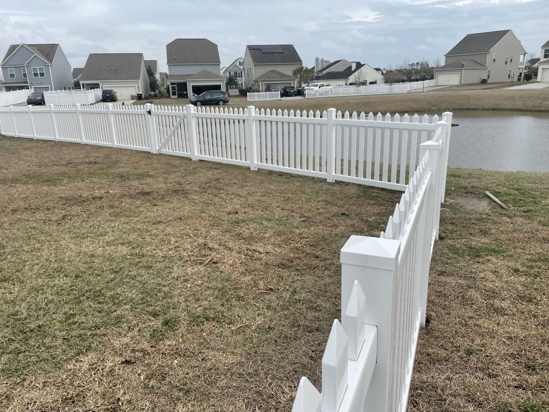 White vinyl scallop picket curving toward the pond, Bluffton